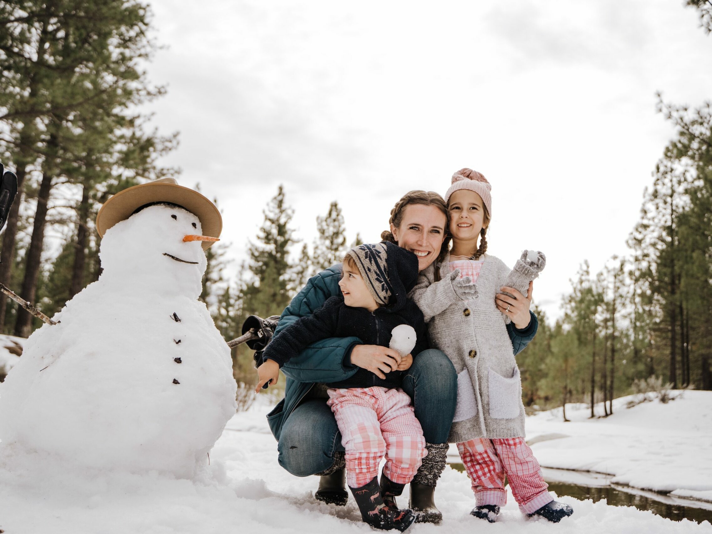 photo of mom and two kids with a snowman